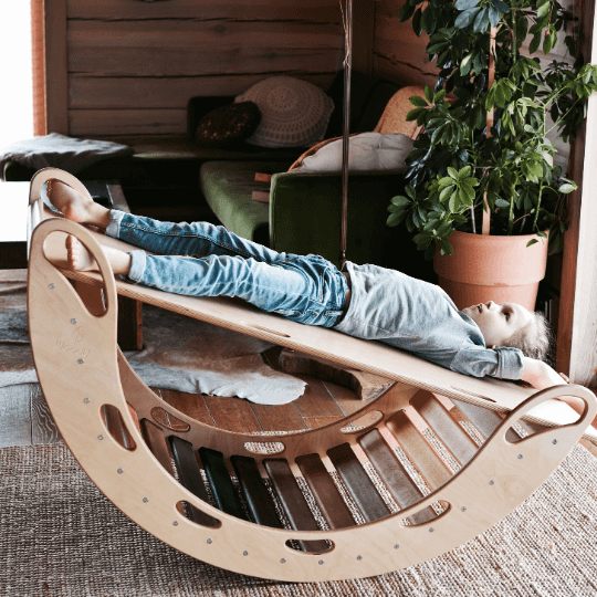 Dziecko leżące na drewnianej rampie umieszczonej na bujaku WoodU